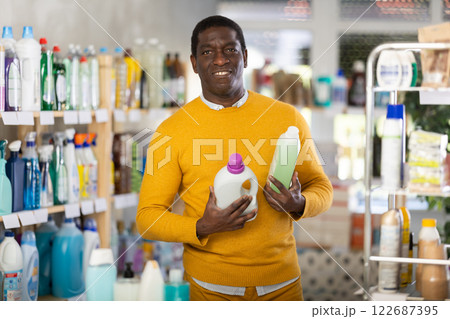 Male consumer with household chemical products for washing indoors Male consumer with household chemical products for washing indoors 122687395