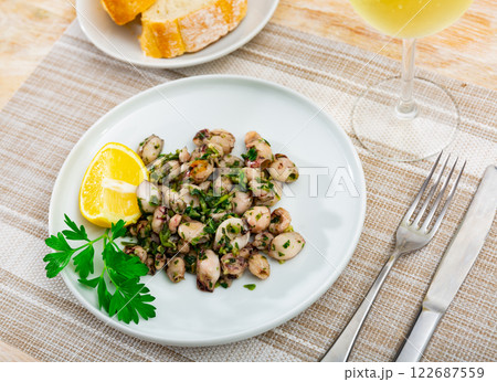 Delicious fried baby squid dish with herbs and lemon 122687559