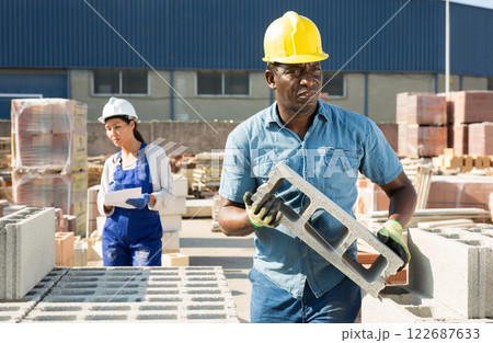 African american worker warehouse lays bricks African american worker warehouse lays bricks 122687633