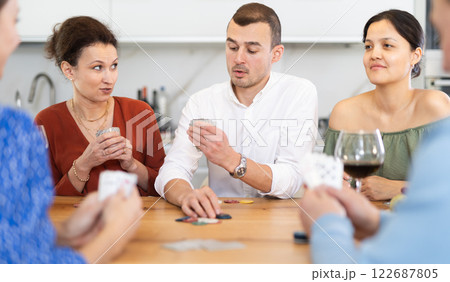 Multiethnic women and men friends playing poker 122687805