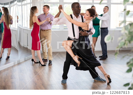 Woman dances incendiary tango with African man partner during choreography lesson 122687813