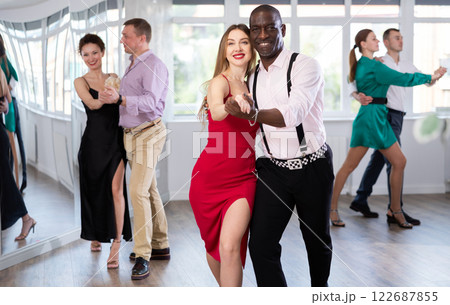 Woman with African man dancing waltz in couple during lesson at studio 122687855