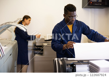 Attentive african american man uses plotter in printing shop 122687924