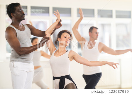 Male trainer teaches group ballet movements 122687959