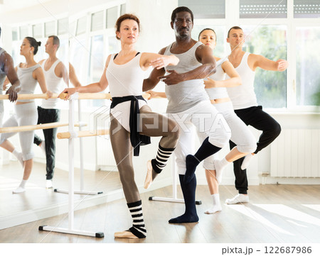 Graceful woman mastering passe move at ballet barre in studio 122687986