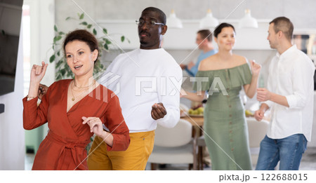 Dance moves of men and woman of different nationalities at fun holiday party at home 122688015
