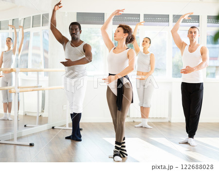 Graceful woman leading ballet class with adult amateur dancers 122688028