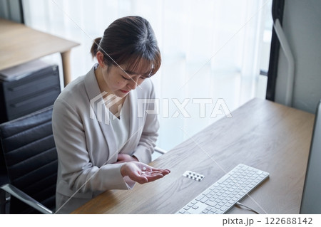 体調不良で薬を飲む女性 122688142