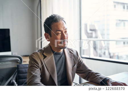 仕事中、眠気に襲われる男性 122688370