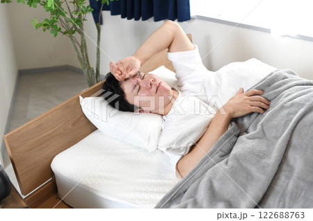 睡眠中に苦しそうな表情をするアジア人男性 睡眠中に苦しそうな表情をするアジア人男性 122688763