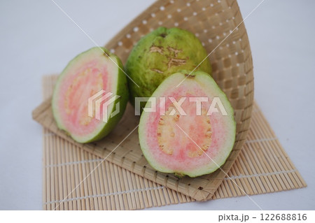 Fresh guava fruit cut in half on bamboo mat 122688816