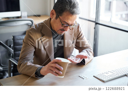薬を飲む男性 122688921