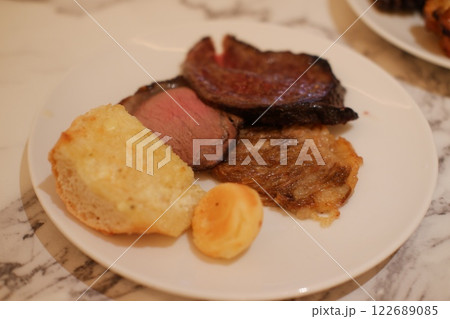 French toast with fried meat and potato chips on a white plate. 122689085