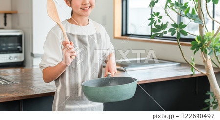 家のキッチンにいるエプロン姿の小学生・中学生の女の子 家のキッチンにいるエプロン姿の小学生・中学生の女の子 122690497