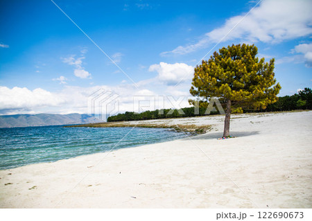 Sandy beach. Seaside vacation, golden beaches. Blue waters of the sea. Lake, ocean, sea 122690673