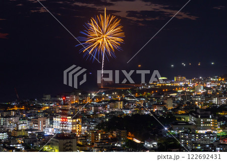 沖縄県名護市名護城公園さくらの園　琉球寒緋桜が咲く高台からの名護市街の夜景と海岸の打ち上げ花火 122692431