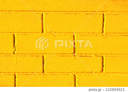 The walls of the house are made of bricks and painted yellow. 122693021