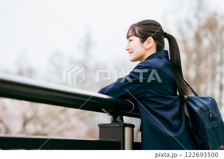 下校・通学・登校中に待ち合わせ・景色を眺める制服姿の女子高校生・女子高生・女子中学生 122693500