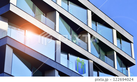 Modern apartment buildings on a sunny day with a blue sky. Facade of a modern apartment building. Glass surface with sunlight. 122694024