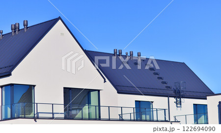 Terraced family homes in newly developed housing estate. The real estate market in the suburbs. New single family houses in a new development area. Residential homes with modern facade.  122694090