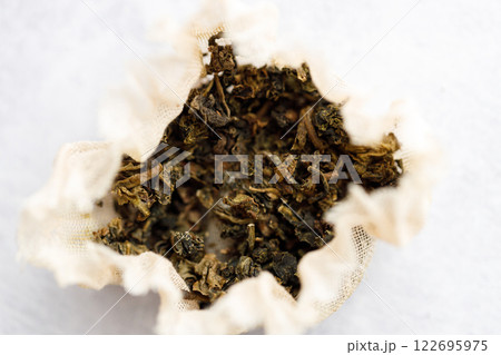 Closeup of dry tea bag on white table background. 122695975