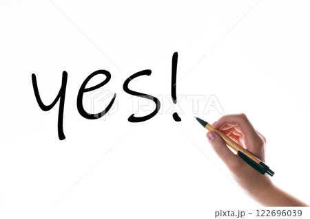 Children hand with pen write on an blue white background. Writing hand. Word YES 122696039