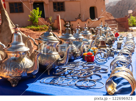 Multicolored Moroccan craft souvenirs at the market. Teapots and plates , decorations, tagines,, trinkets 122696923