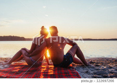Romantic couple on the beach at colorful sunset on background 122697266
