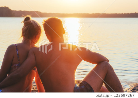 Romantic couple on the beach at colorful sunset on background 122697267