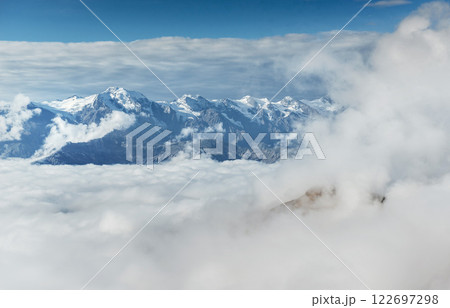 Autumn landscape and snow mountains in beautiful cumulus clouds. Main Caucasian Ridge. Type Mount Ushba Mheyer, Georgia 122697298