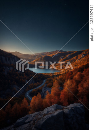 an impressive autumn landscape, forest and mountains at night, a road to the horizon and a lake, starry sky, beautiful nature 122697414