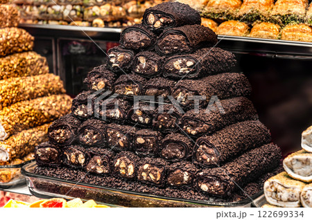 A pyramid of delicious Turkish delight, dark and richly textured, sits proudly displayed. Walnuts are visible within the sweet rolls 122699334