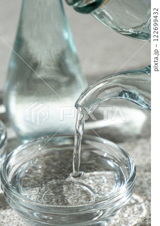 White distilled vinegar is poured into a glass vinegar bowl. White distilled vinegar is poured into a glass vinegar bowl. 122699432