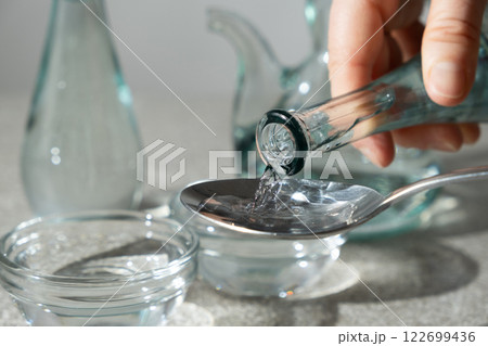 White distilled vinegar is poured into a glass vinegar bowl. White distilled vinegar is poured into a glass vinegar bowl. 122699436