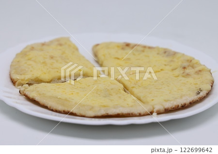 Pita warmed up with cheese lies on a plate, pita cut into pieces, proper nutrition 122699642