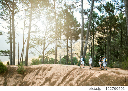 Adventure, hiking and discovery with a group of senior friends exploring the forest or woods during a hike. Beauty, nature and view with mature people walking outdoors in the wilderness together 122700691