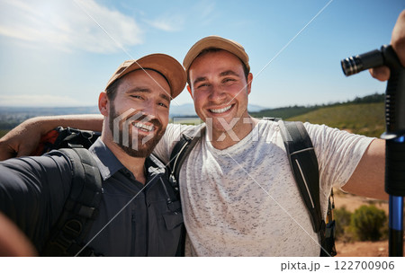 Friends, brothers or hikers taking a selfie while hiking outdoors in nature sharing the experience on social media. Active, fit and athletic men take a picture or a photo while trekking 122700906
