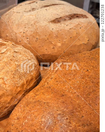 Freshly baked artisanal bread loaves displayed in a cozy bakery setting 122701238