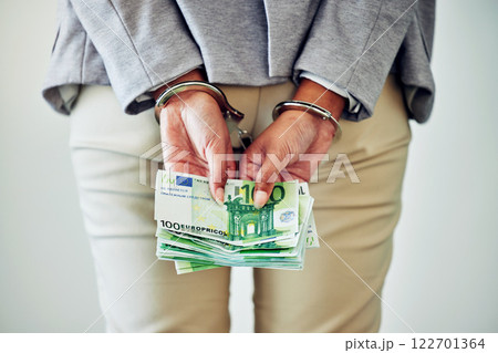 Corporate fraud, stealing or money laundering deal of a business woman with handcuffs and cash. Back hands view of legal justice of a caught white collar work employee going to court, jail or prison 122701364