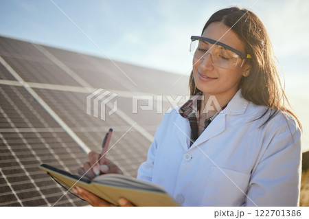 Solar panel, solar energy and electricity expert writing renewable energy research results on environment sustainability. Scientist for innovation and global development with future growth report Solar panel, solar energy and electricity expert writing renewable energy research results on environment sustainability. Scientist for innovation and global development with future growth report 122701386