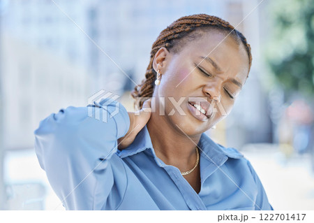 Woman manager with stress and pain in her neck while standing outside the office building. Female business leader at work with aching muscle in need of a wellness massage or a medical doctor for help 122701417
