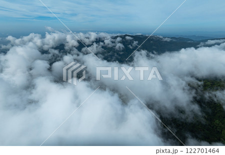 Aerial view Panorama of flowing fog waves on mountain tropical rainforest,Bird eye view image over the clouds Amazing nature background Aerial view Panorama of flowing fog waves on mountain tropical rainforest,Bird eye view image over the clouds Amazing nature background 122701464