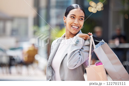 Shopping, retail and customer with bags to shop at a store or mall in the city. Sale, money and consumer lifestyle with a happy, young woman spending, buying and purchase against an urban background 122701511