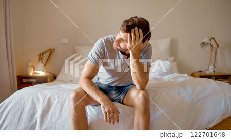 Depression, mental health and sad man in stress feeling bad, upset and depressed alone in his home, house or hotel suite. Wake up, morning and frustrated, unhappy male in bedroom tired with anxiety Depression, mental health and sad man in stress feeling bad, upset and depressed alone in his home, house or hotel suite. Wake up, morning and frustrated, unhappy male in bedroom tired with anxiety 122701648
