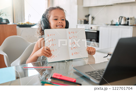 Zoom class, virtual teaching lesson and online education with clever kid showing math homework, test and sums for distance learning on video call with laptop. Home school child, girl and student 122701704