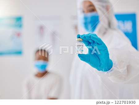 Covid, corona virus vaccine or vaccination with healthcare worker hands showing liquid glass container or bottle. Medical doctor preparing a coronavirus prevention dosage shot for patient in hospital Covid, corona virus vaccine or vaccination with healthcare worker hands showing liquid glass container or bottle. Medical doctor preparing a coronavirus prevention dosage shot for patient in hospital 122701930