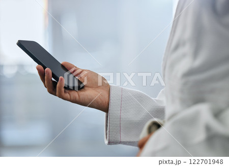 Karate student athlete hand texting message on a phone at sport gym and browsing the internet with online social media app. Networking on 5g wireless mobile device or smartphone on the web with wifi Karate student athlete hand texting message on a phone at sport gym and browsing the internet with online social media app. Networking on 5g wireless mobile device or smartphone on the web with wifi 122701948