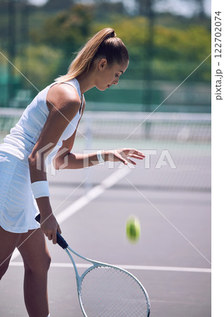 Female tennis player with ball and racket gear in a tournament match or fun outdoor hobby activity. Sports, active and fit woman preparing to serve opponent during a competitive or training exercise 122702074