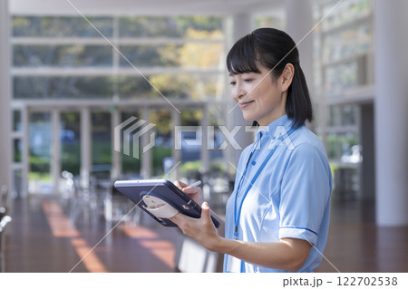 タブレットを操作する施設スタッフ　イメージ 122702538