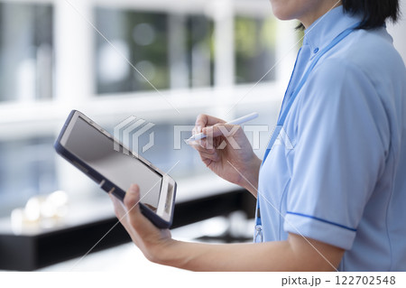 タブレットを持った施設スタッフの手元 タブレットを持った施設スタッフの手元 122702548